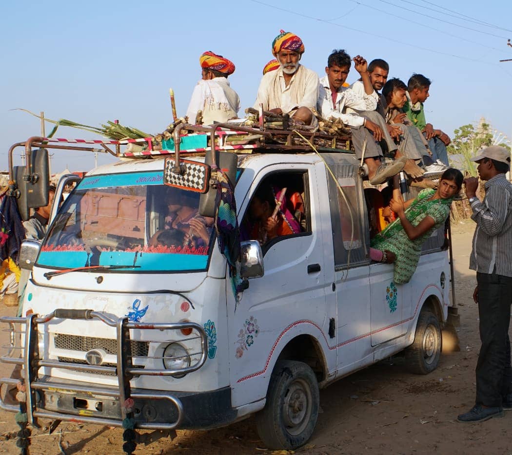 People riding in small truck box