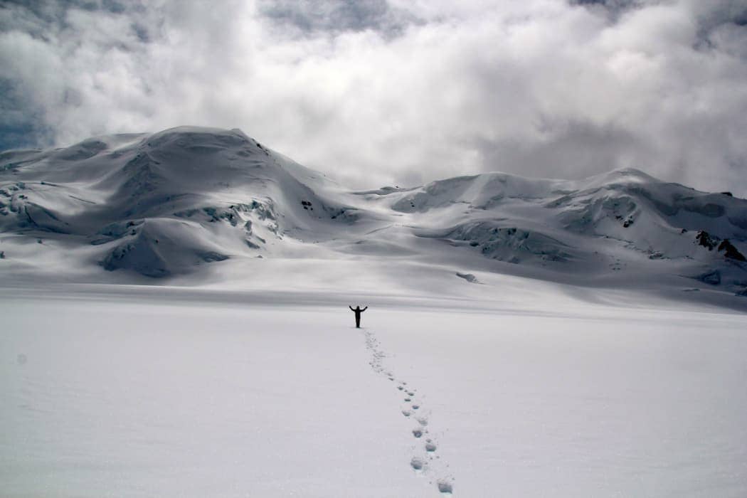 Person walking towards the camera with mountains in background