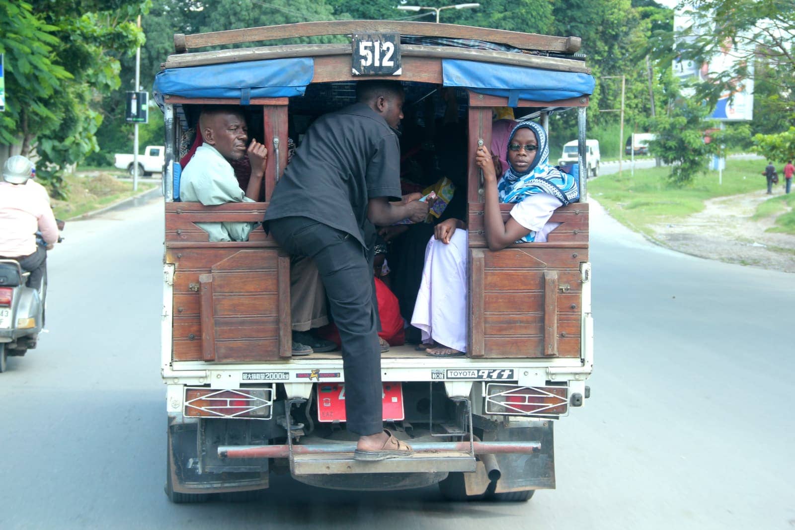 Rear view of truck taxi transporting multiple people