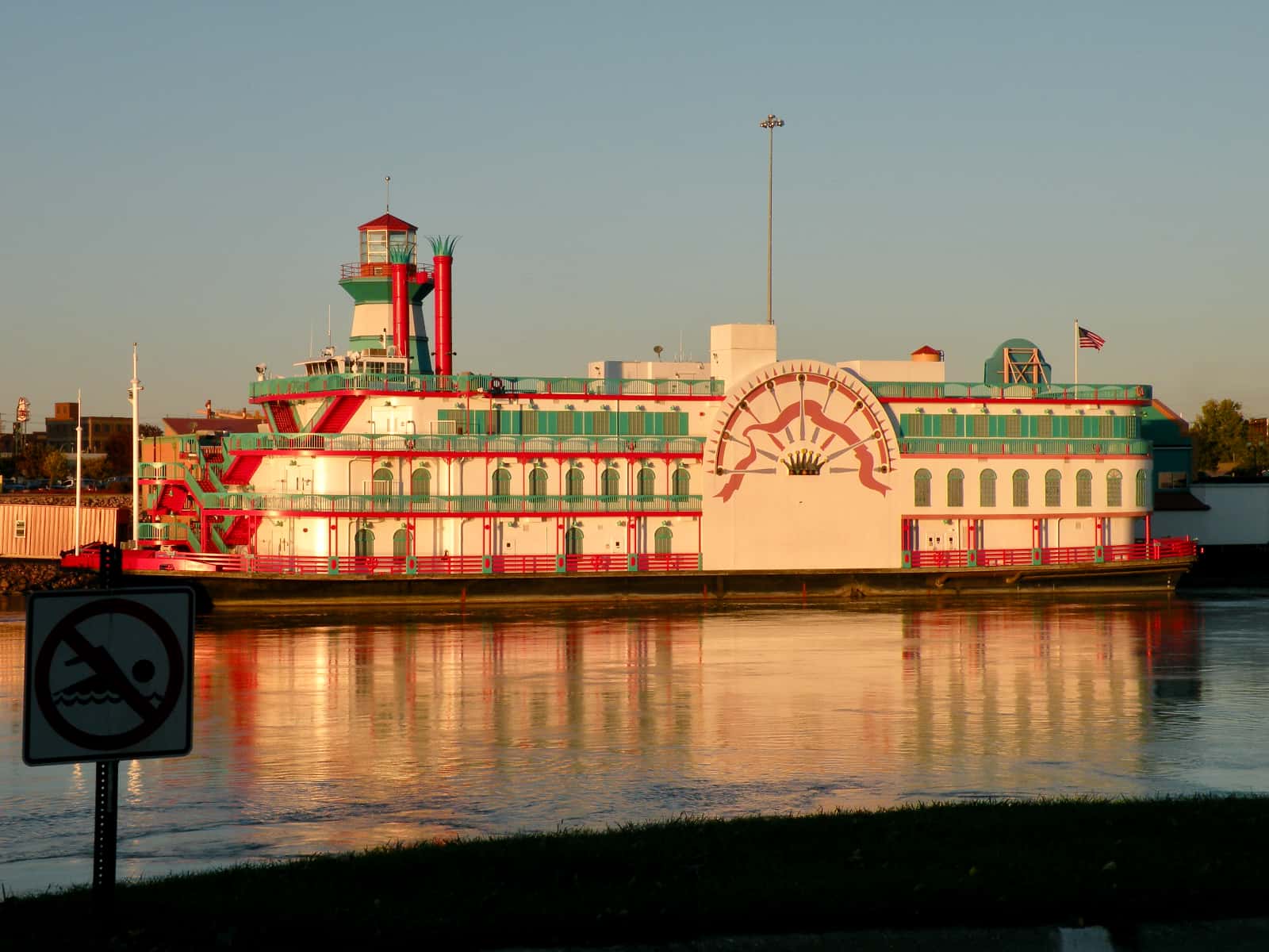 Red white and green paddle steamer in evening sun