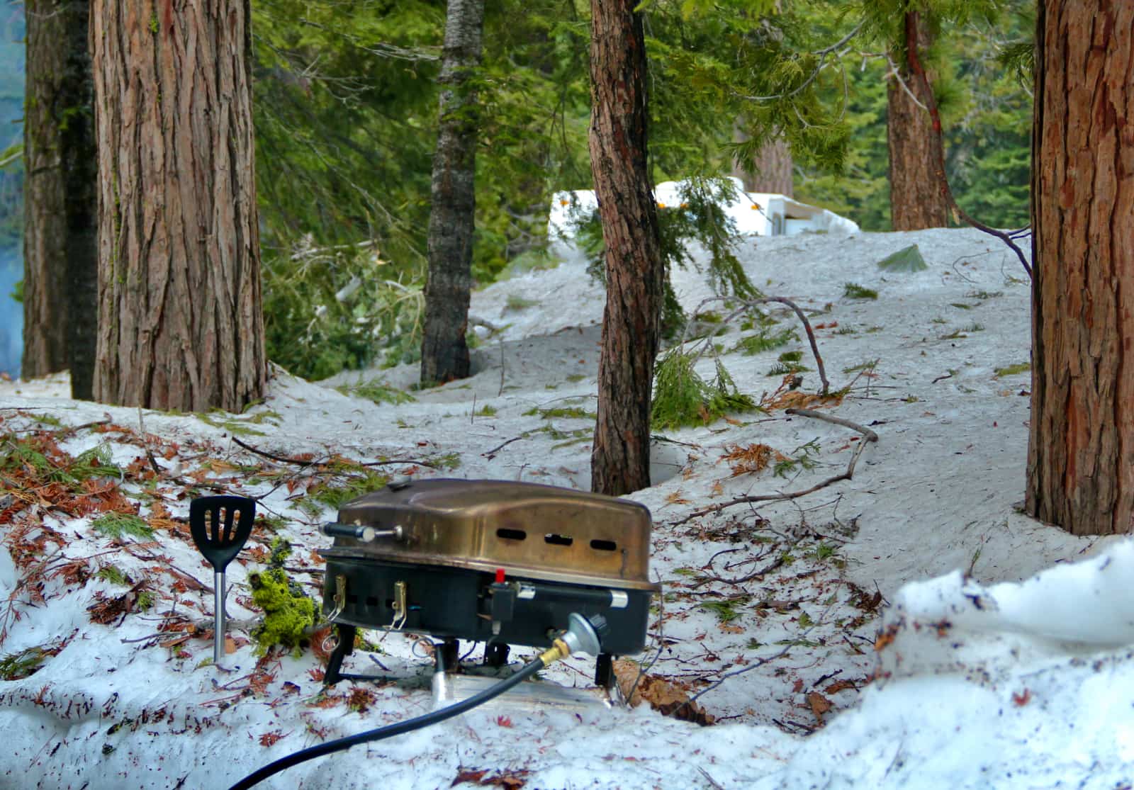 Small camp stove sitting on snow covered ground