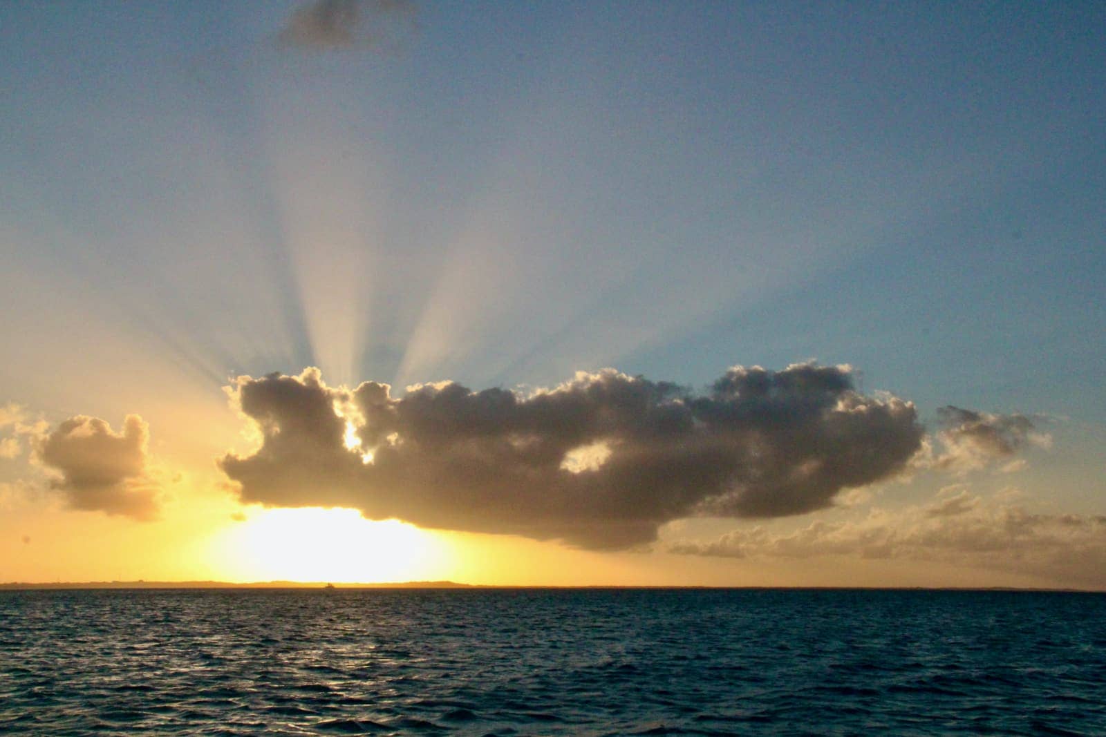 Sun rising over horizon and ocean