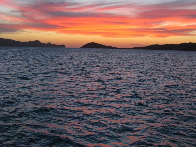 Sunset over ocean with islands in background