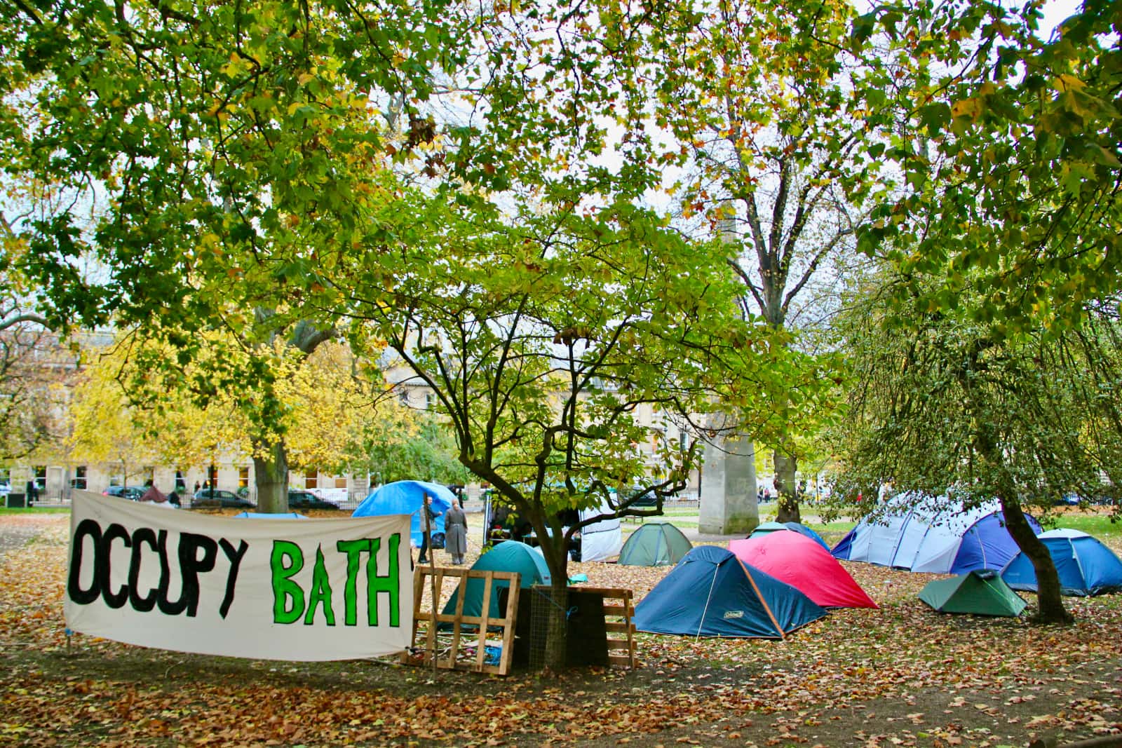 Tents setup in park with Occupy Bath banner on display