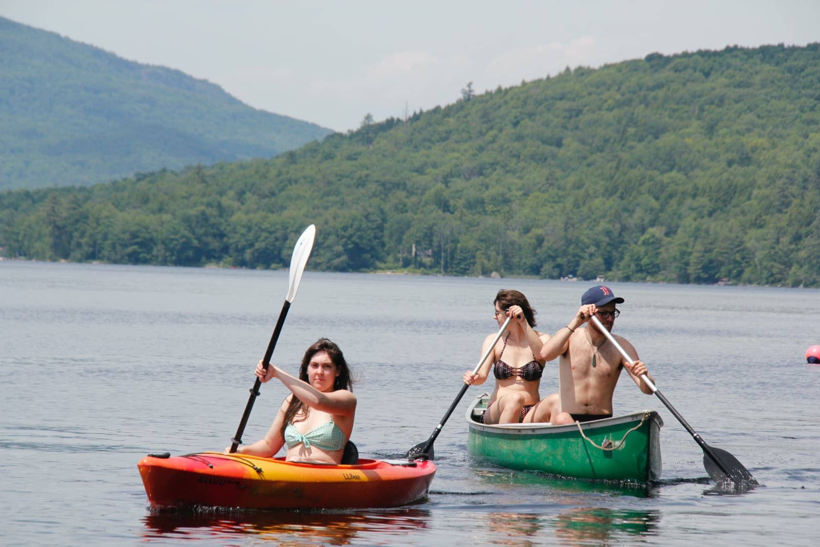 Three people kayaking and canoeing on lake