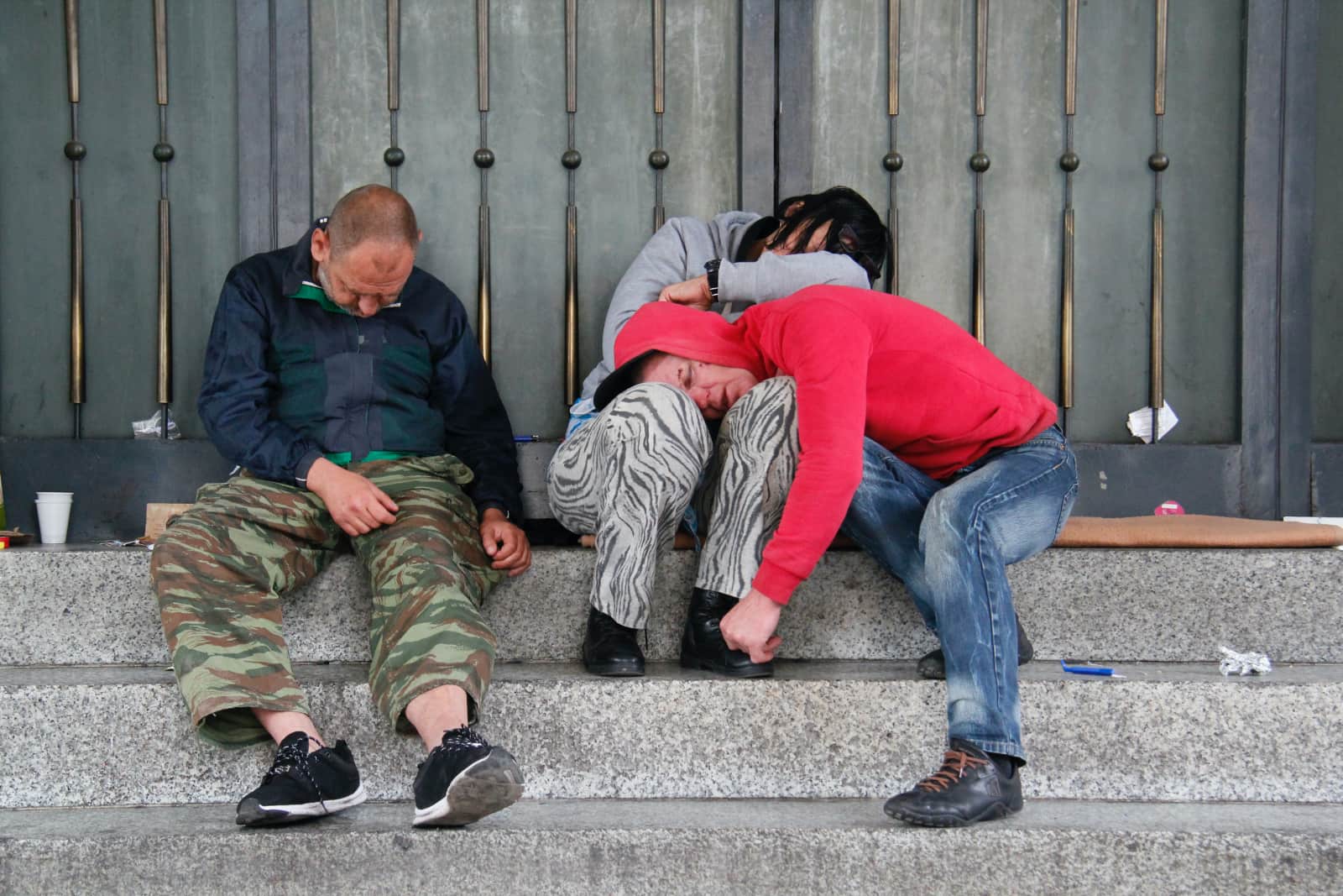 Three people sleeping on steps