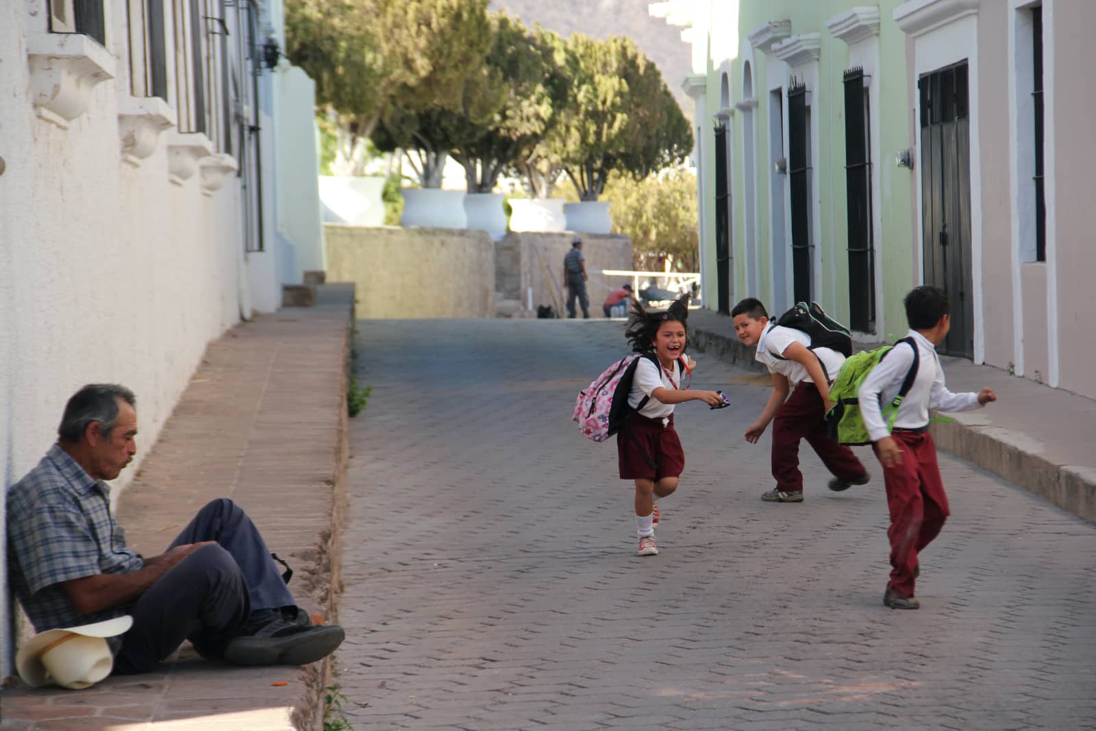 Three young children playing on street