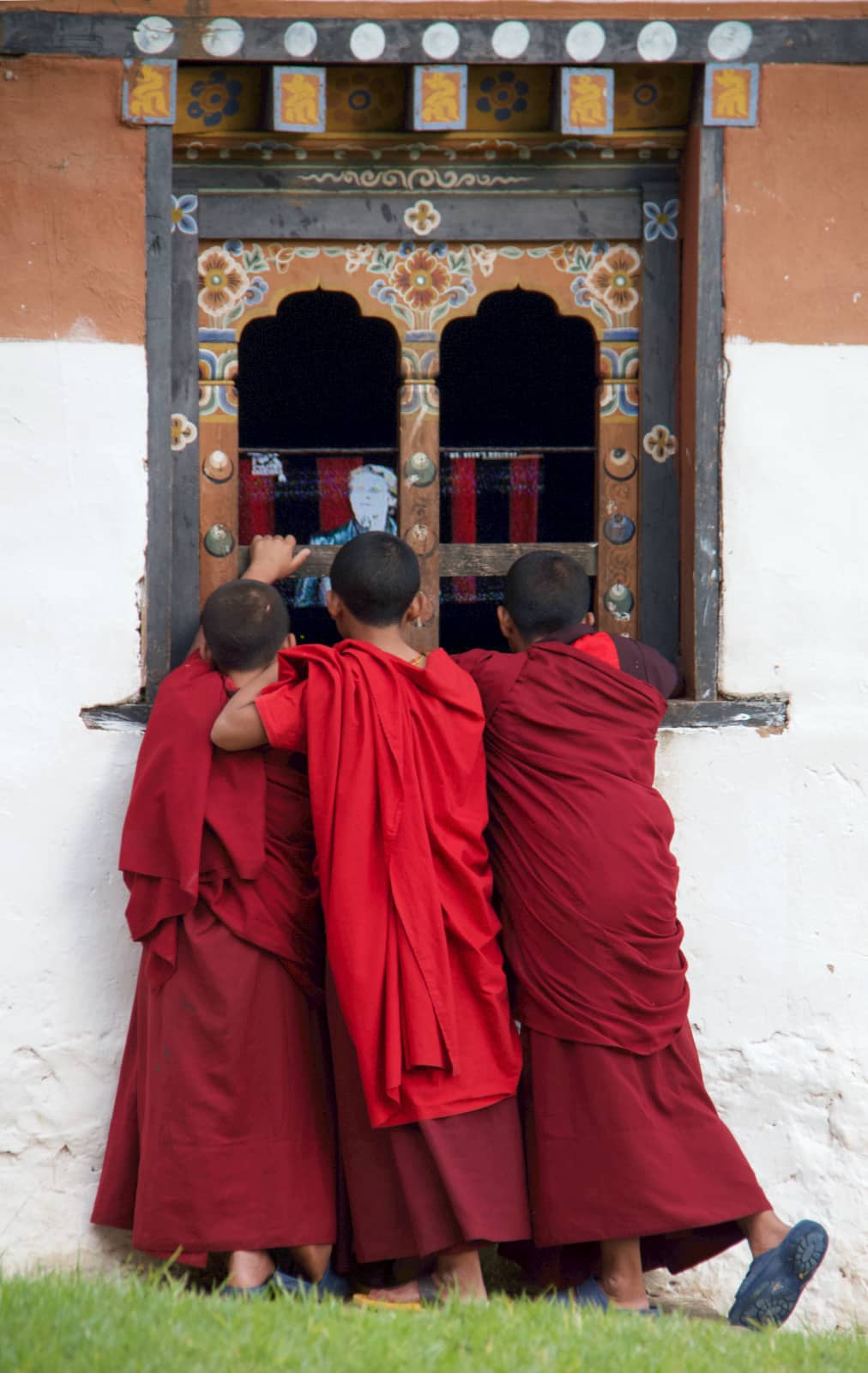 Three young men in red robes