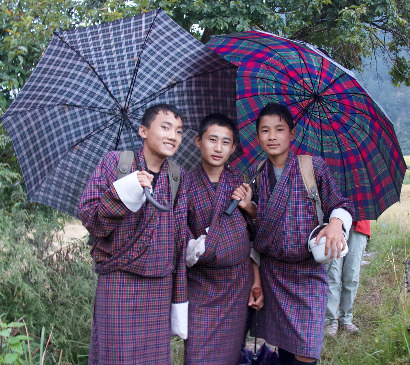 Three young men with umbrellas
