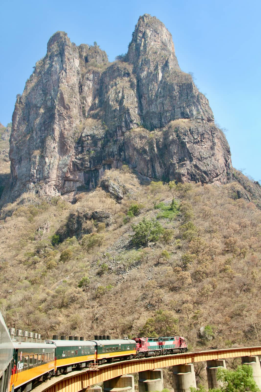 Train on bridge in foreground with mountain in background