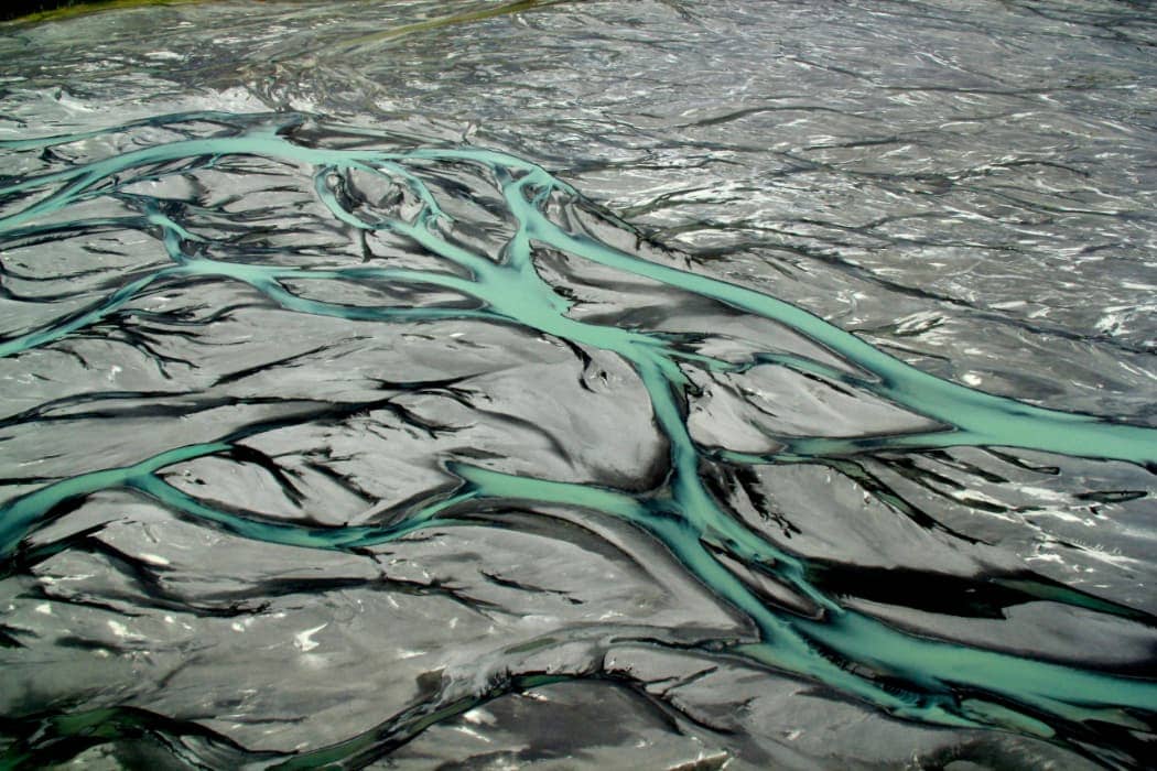 Turquoise water flowing across grey sand