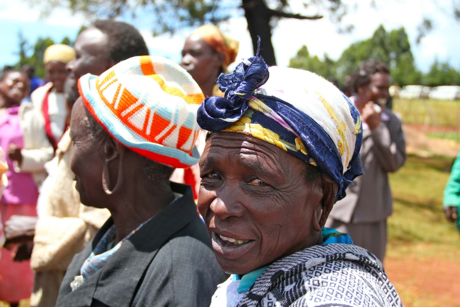 Two elderly African women in foreground with other African women in background