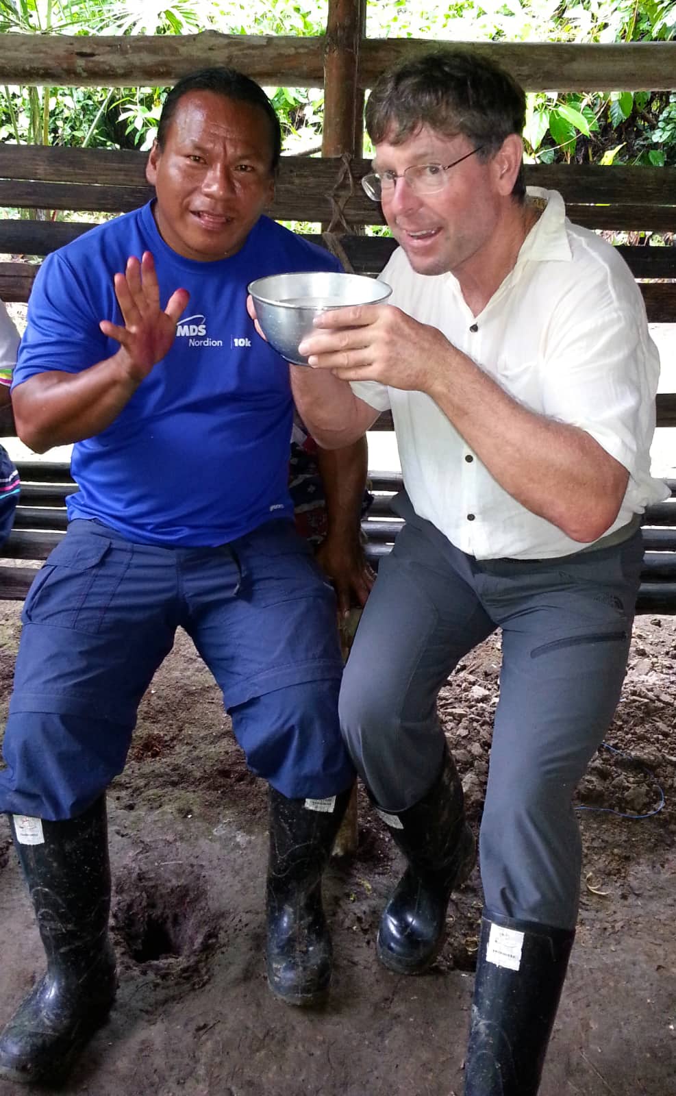 Two men enjoying beverage in Amazon forest