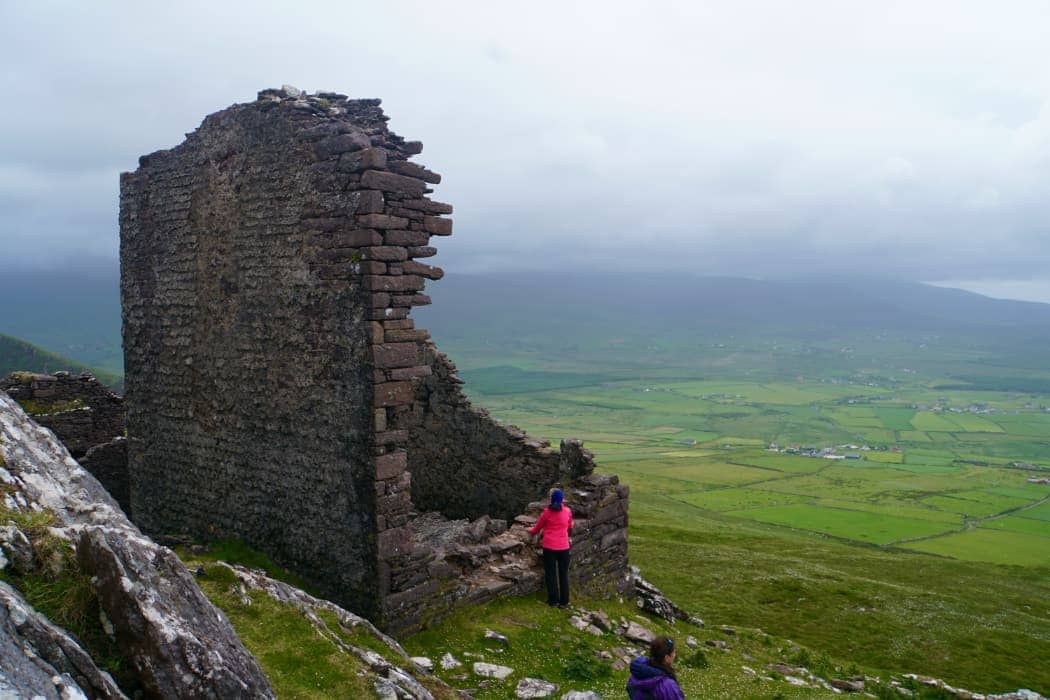 Two people observing castle ruins in countryside