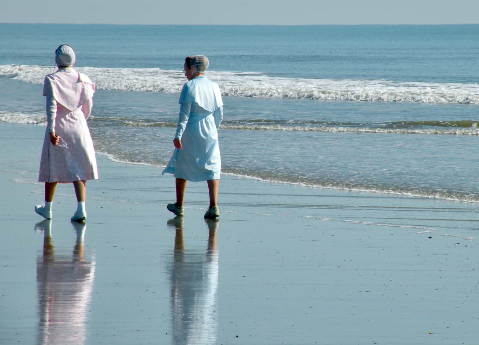 Two woman walking along beach