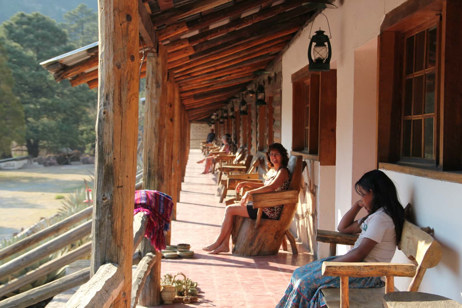 Two women sitting in chairs on long verandah