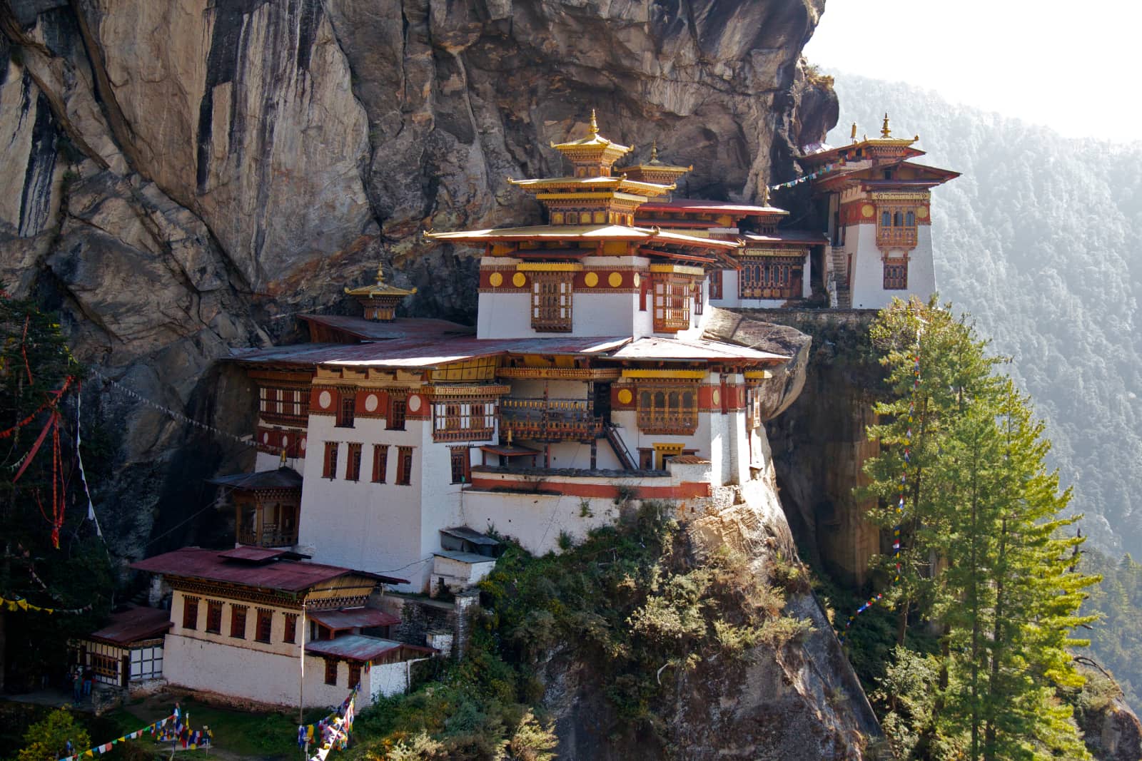 White and red temple on side of mountain