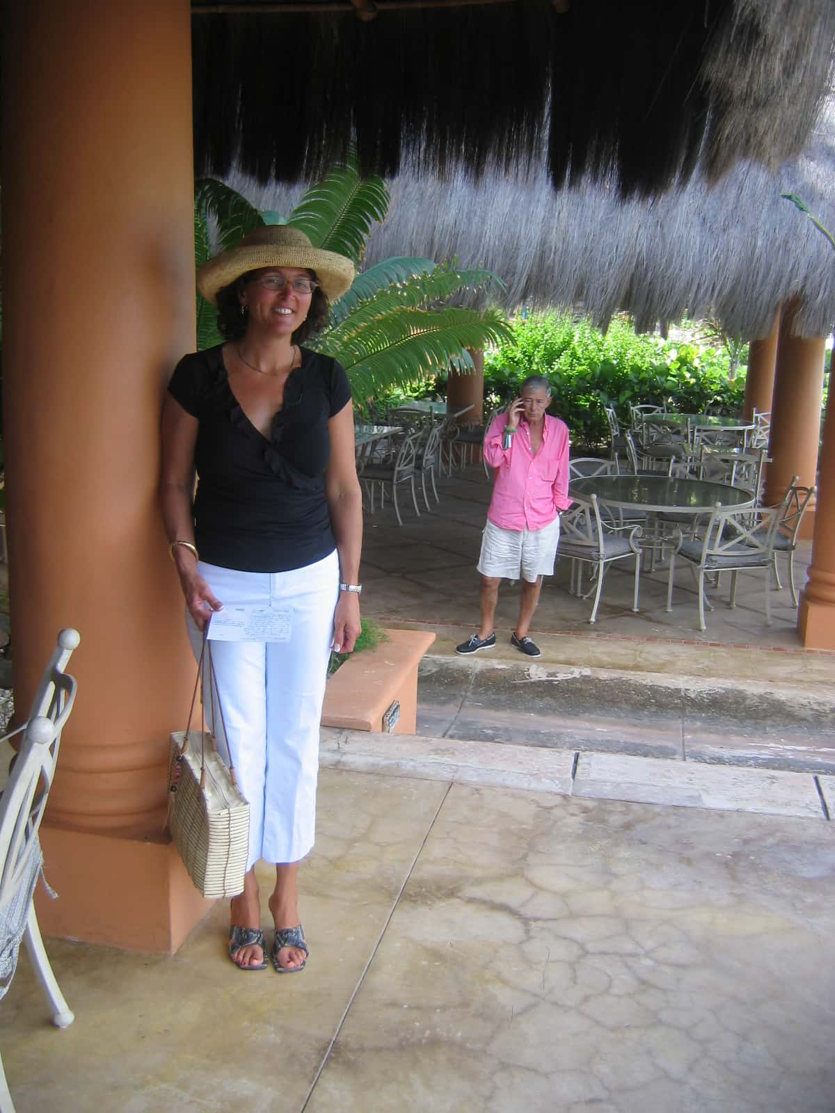 Woman in black shirt standing next to beige support column