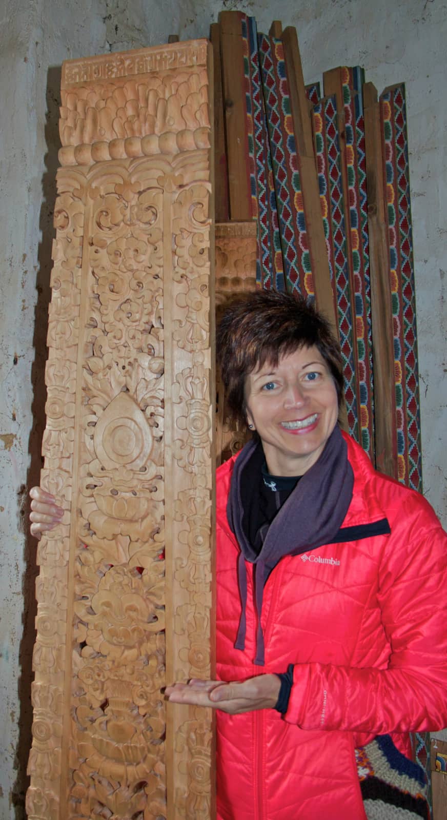 Woman in red jacket standing with decorated wood board