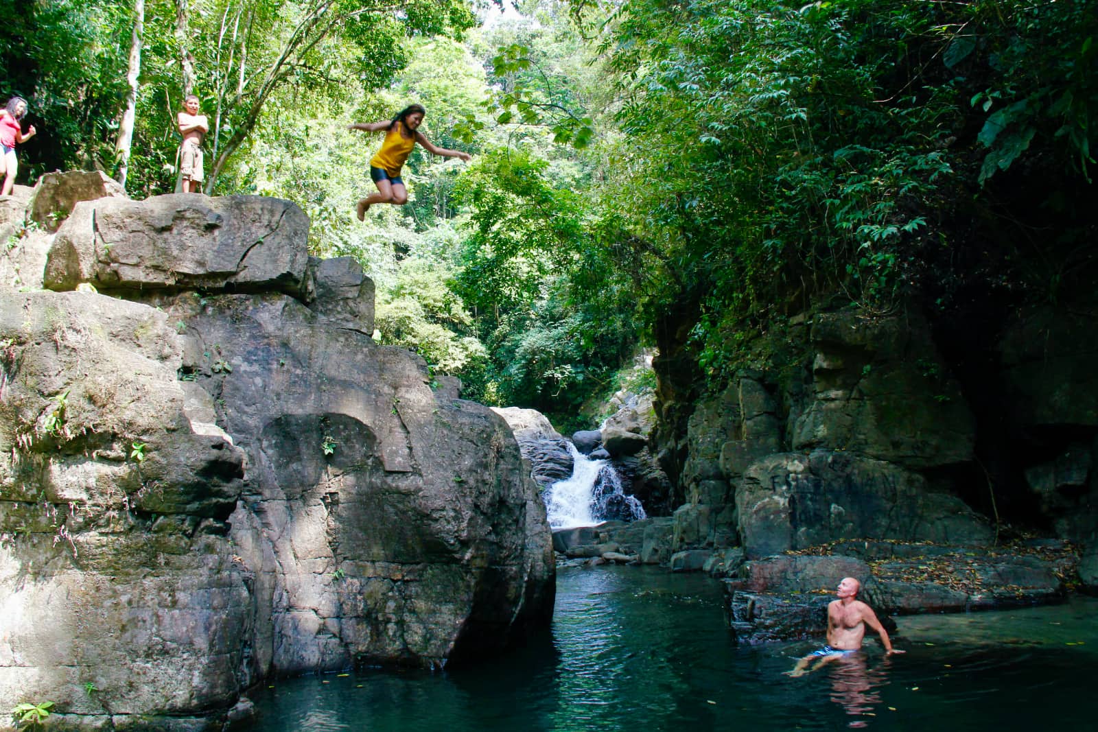 Woman in yellow shirt jumping into pool