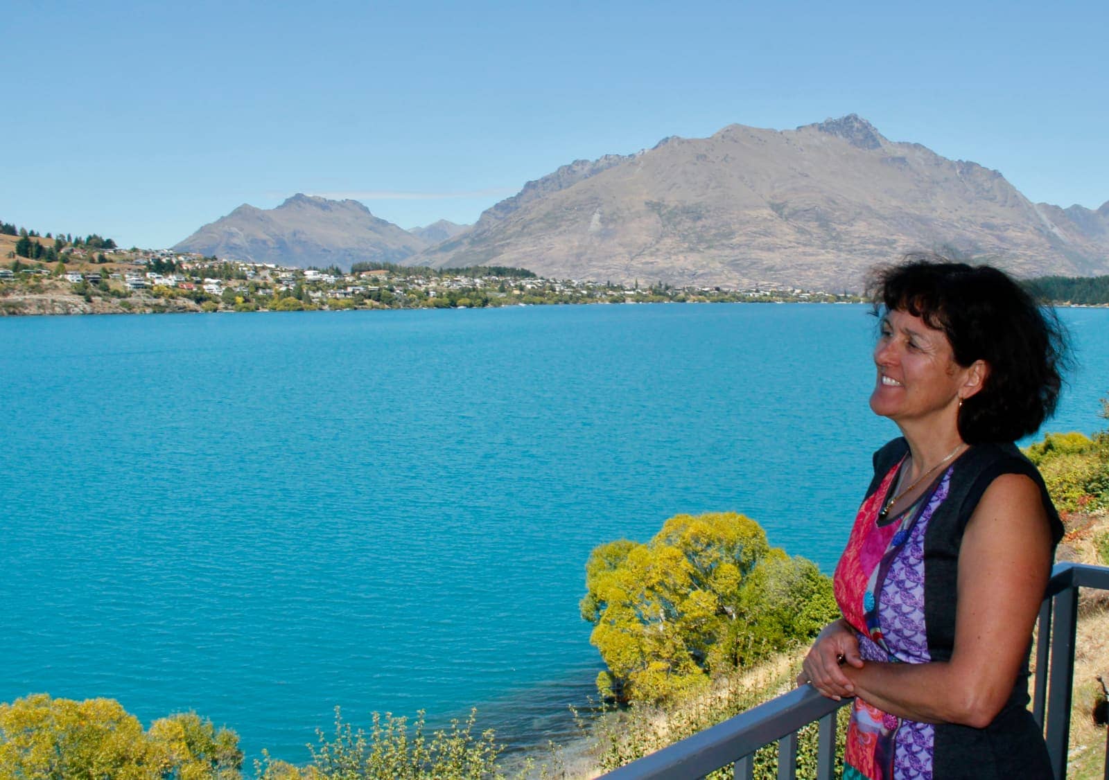 Woman looking over lake from balcony