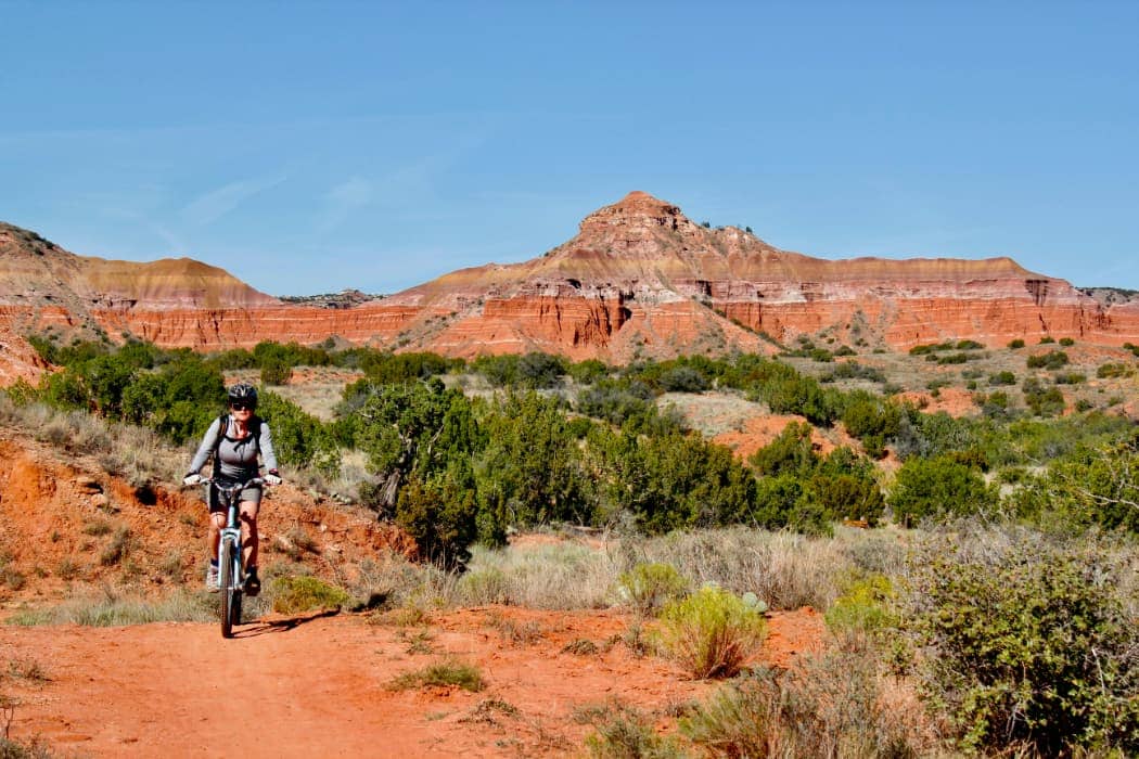 Woman mountain bike riding in desert scrub