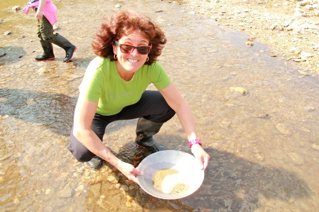 Woman panning for gold in river
