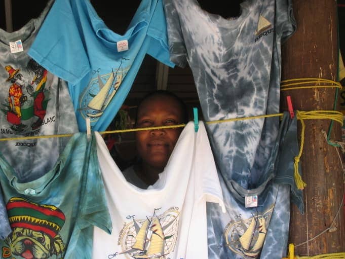 Woman peering through hanging clothes on line