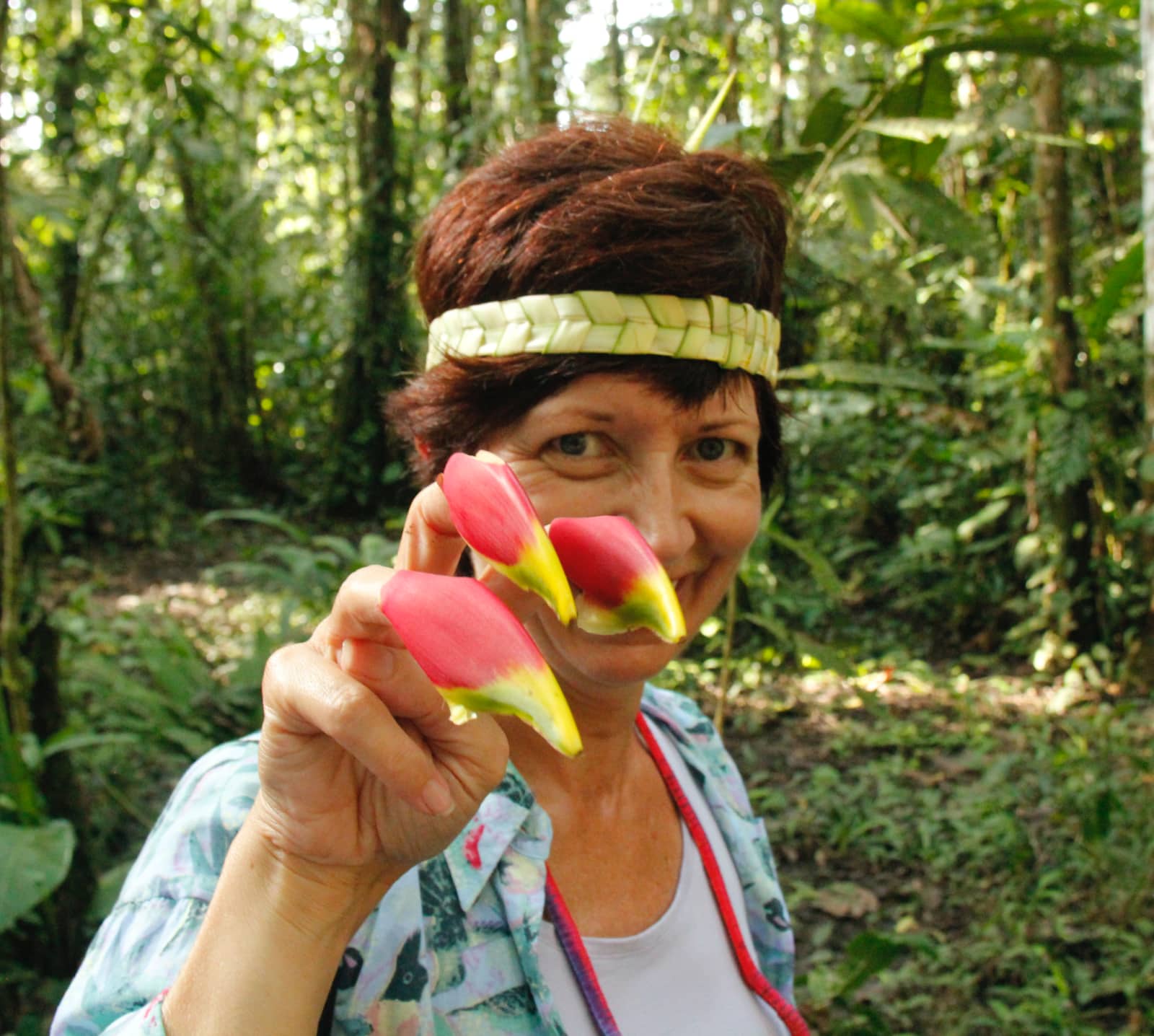 Woman posing with tropical plant on fingers