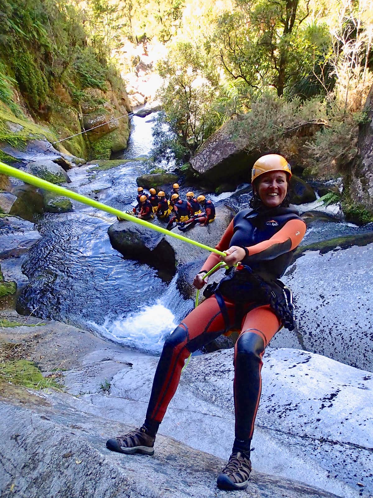 Woman repelling down rock face