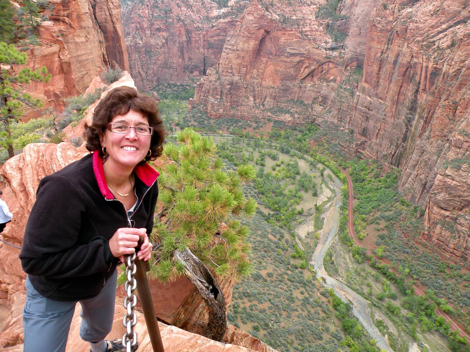 Woman smiling in foreground with winding river in background
