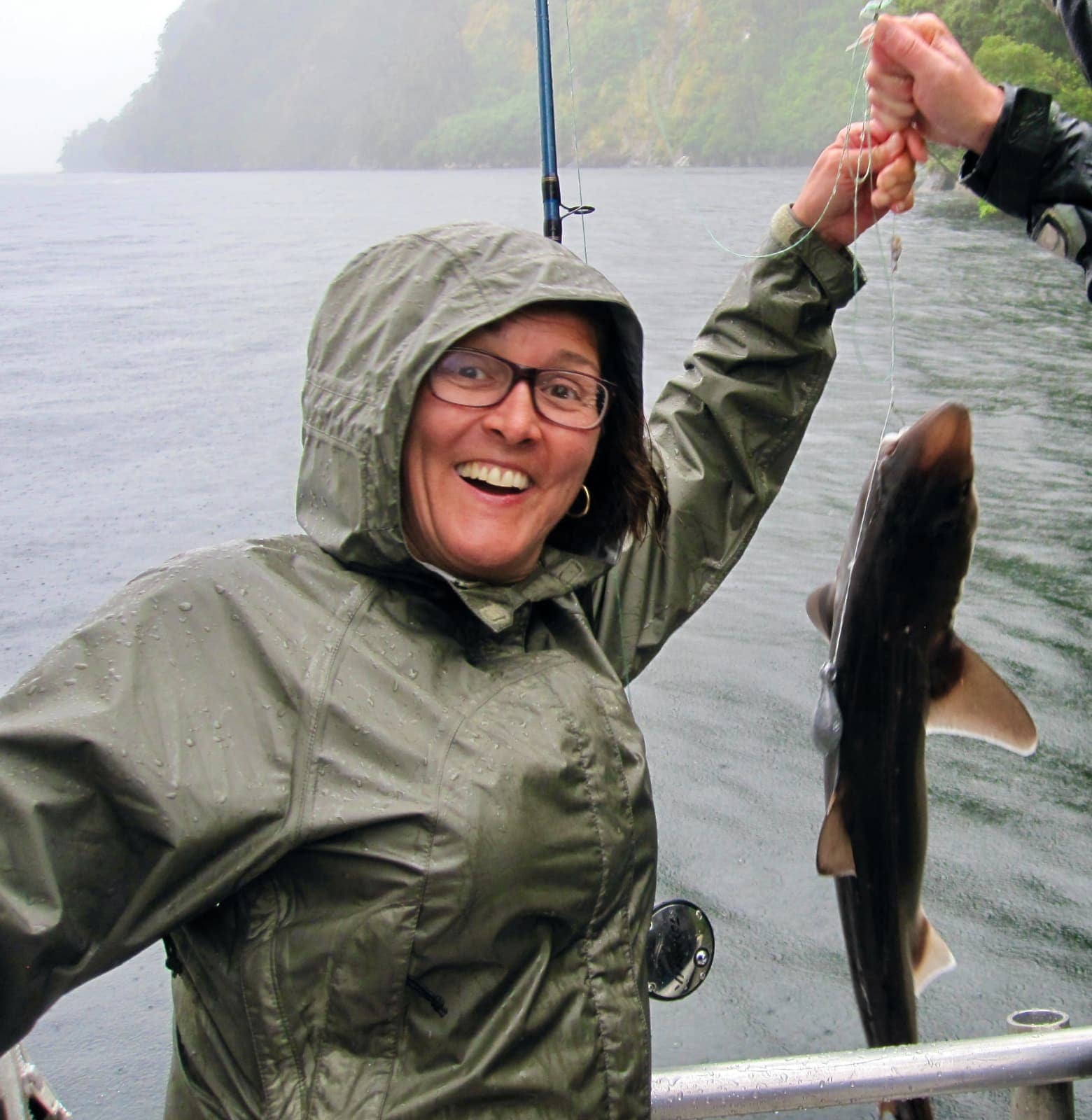 Woman smiling with large fish on fishing line