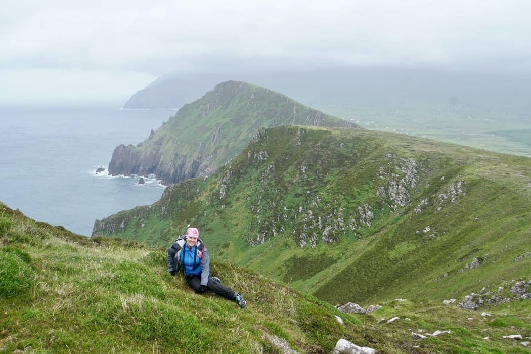 Woman smiling with rugged coastline in background