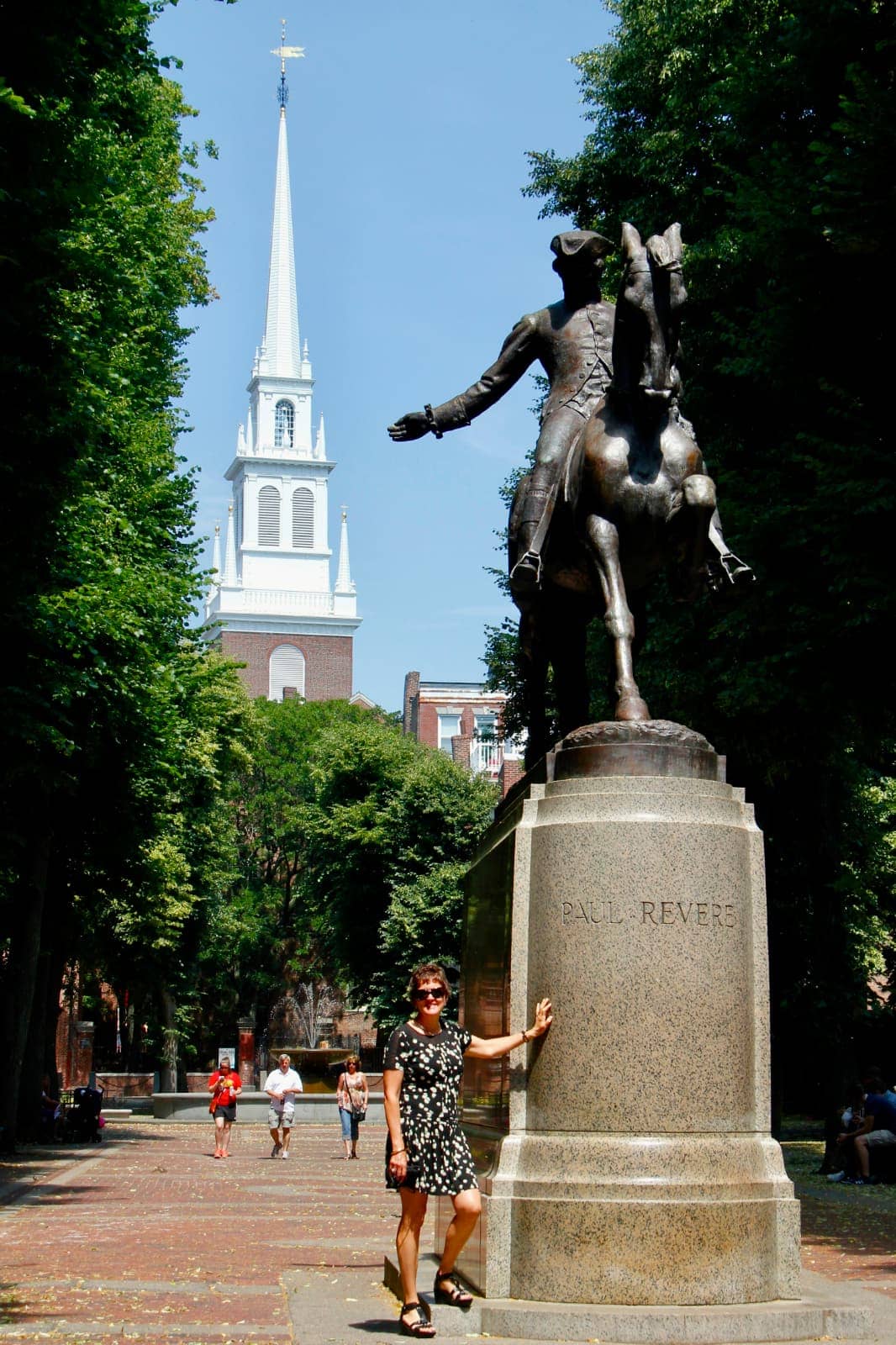 Woman standing next to statue of Paul Revere