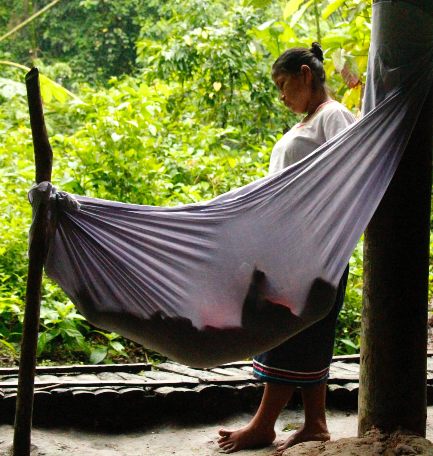 Woman standing with child in hammock