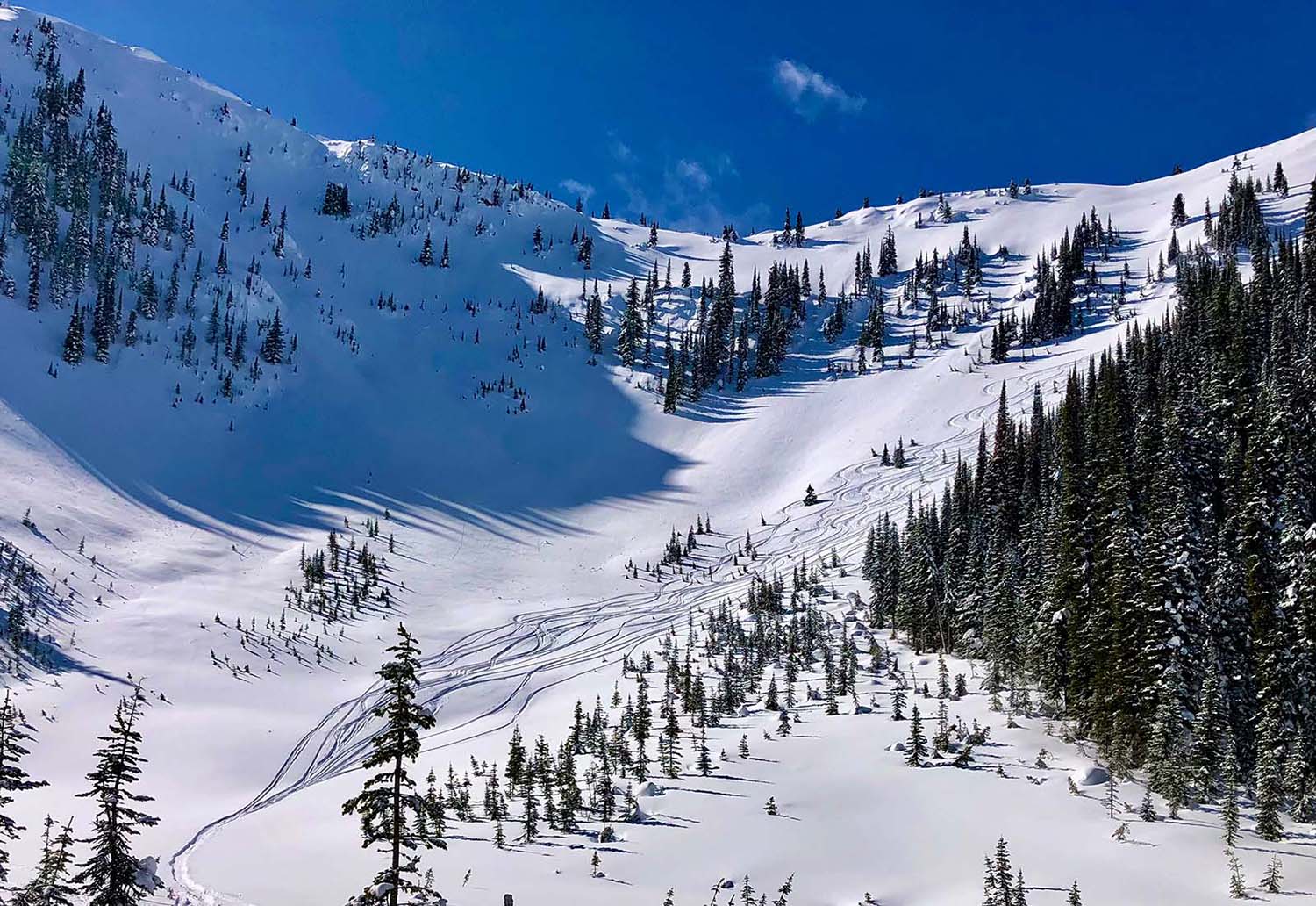 snow-covered alpine mountain with ski tracks