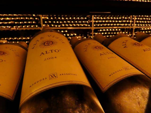 Four wine bottles sitting on shelf in winery