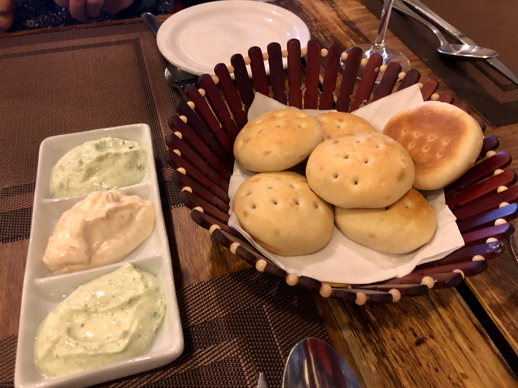 A basket of Patagonian pastries to the right of a plate of various spreads.